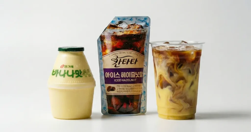 Korean banana milk and hazelnut iced coffee displayed beside a clear plastic cup of layered banana latte, highlighting a popular convenience store DIY drink combination.