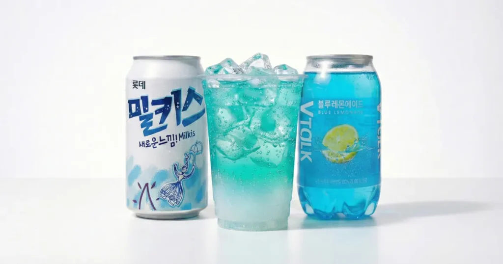 A can of Milkis and a bottle of blue lemonade placed next to a clear plastic cup filled with a blue-to-white gradient soda, representing a visually striking Korean convenience store DIY mocktail.