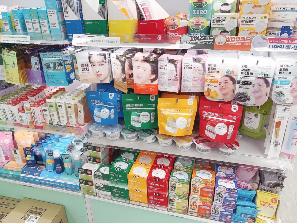 Organized shelves in a Korean Daiso store filled with various facial pads and skincare items with visible price tags